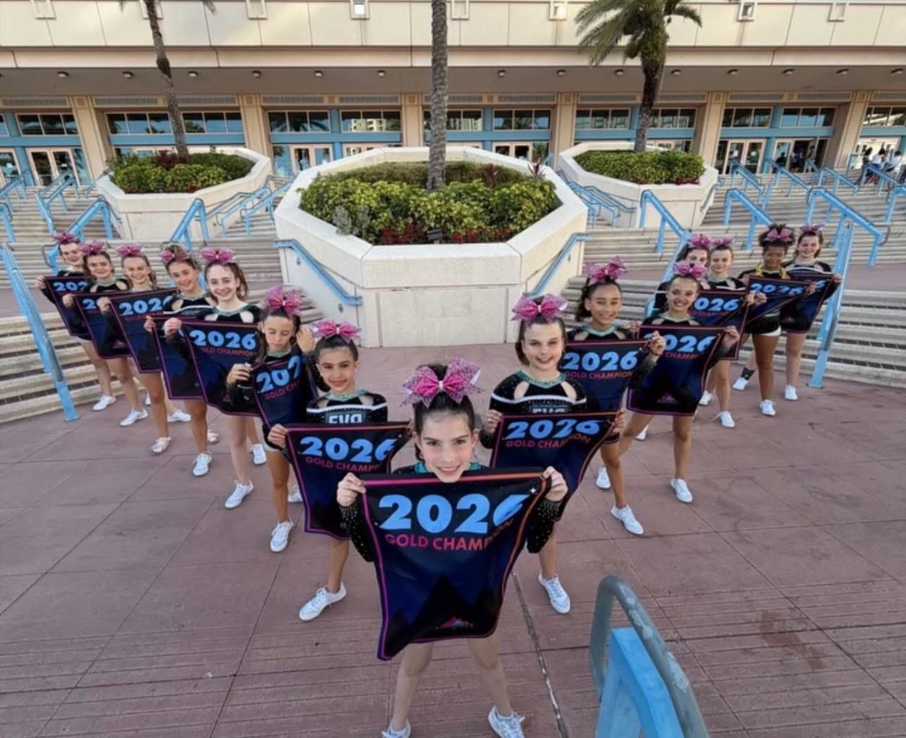 EVA athletes holding 2026 Gold Champion pennants